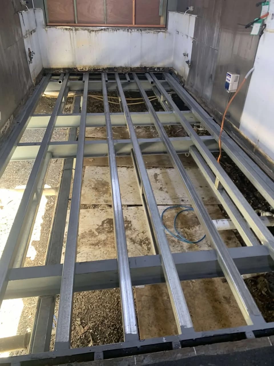 Steel floor framing exposed inside an amenities building during floor refurbishment