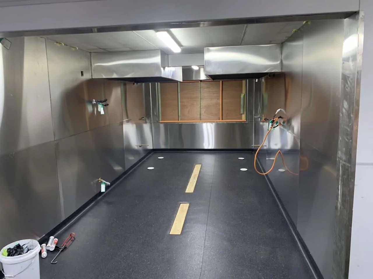 New dark vinyl flooring in an amenities building with tools and finishing work visible
