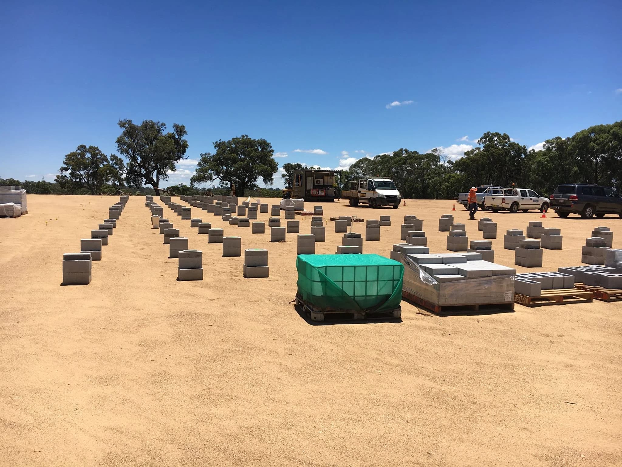 Rows of concrete footings set out across a cleared pad