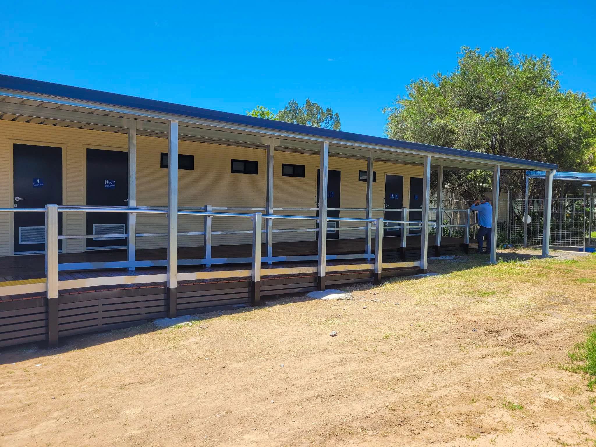 School building with a covered walkway, handrails and new access