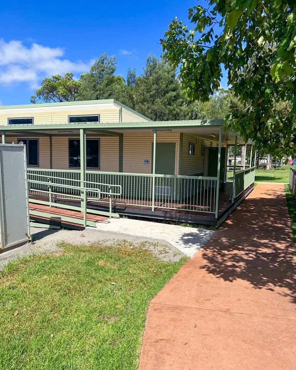 School complex with a covered veranda, green balustrades and timber access ramp