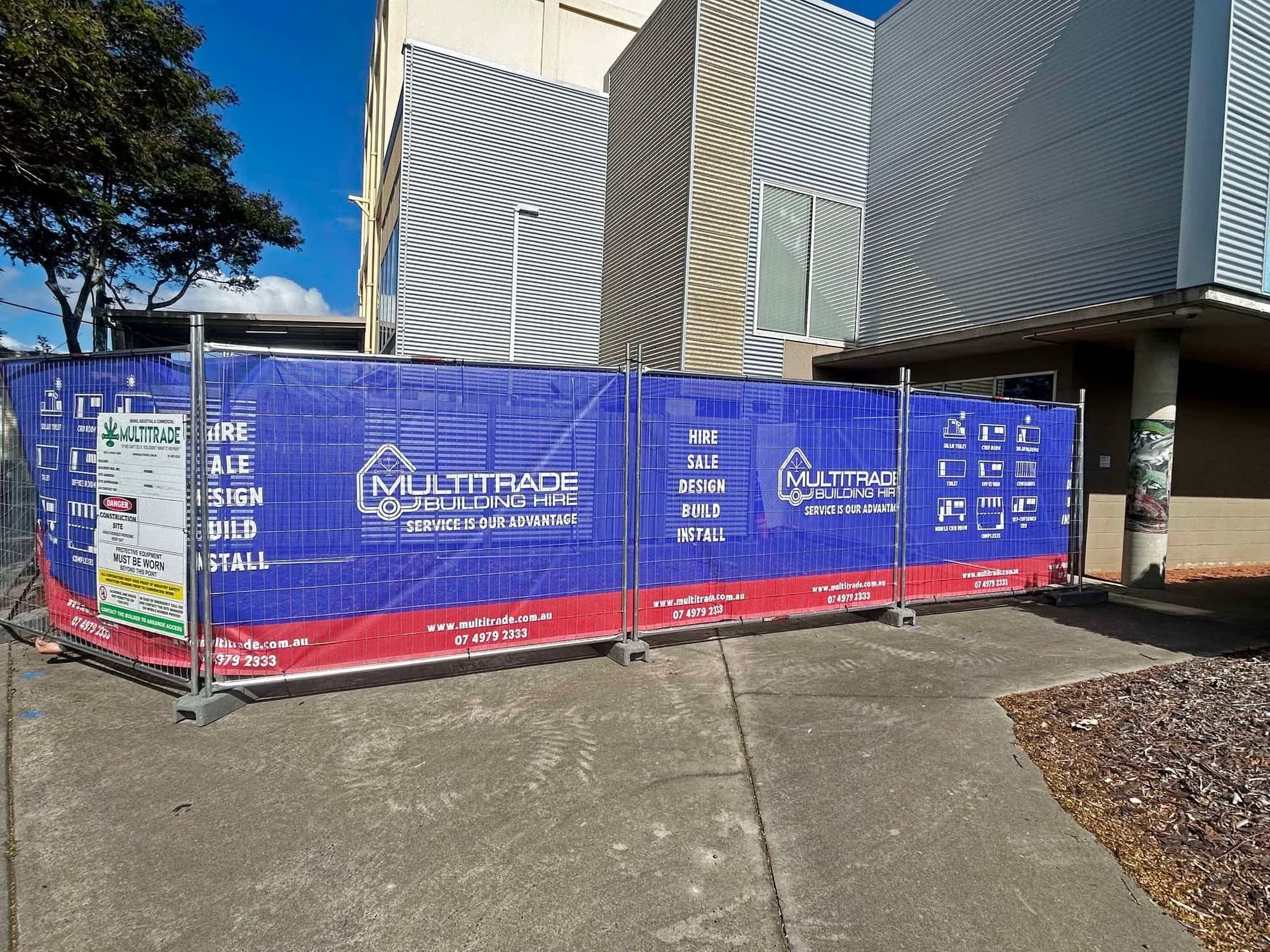 Temporary fencing enclosing the installation work area beside existing buildings