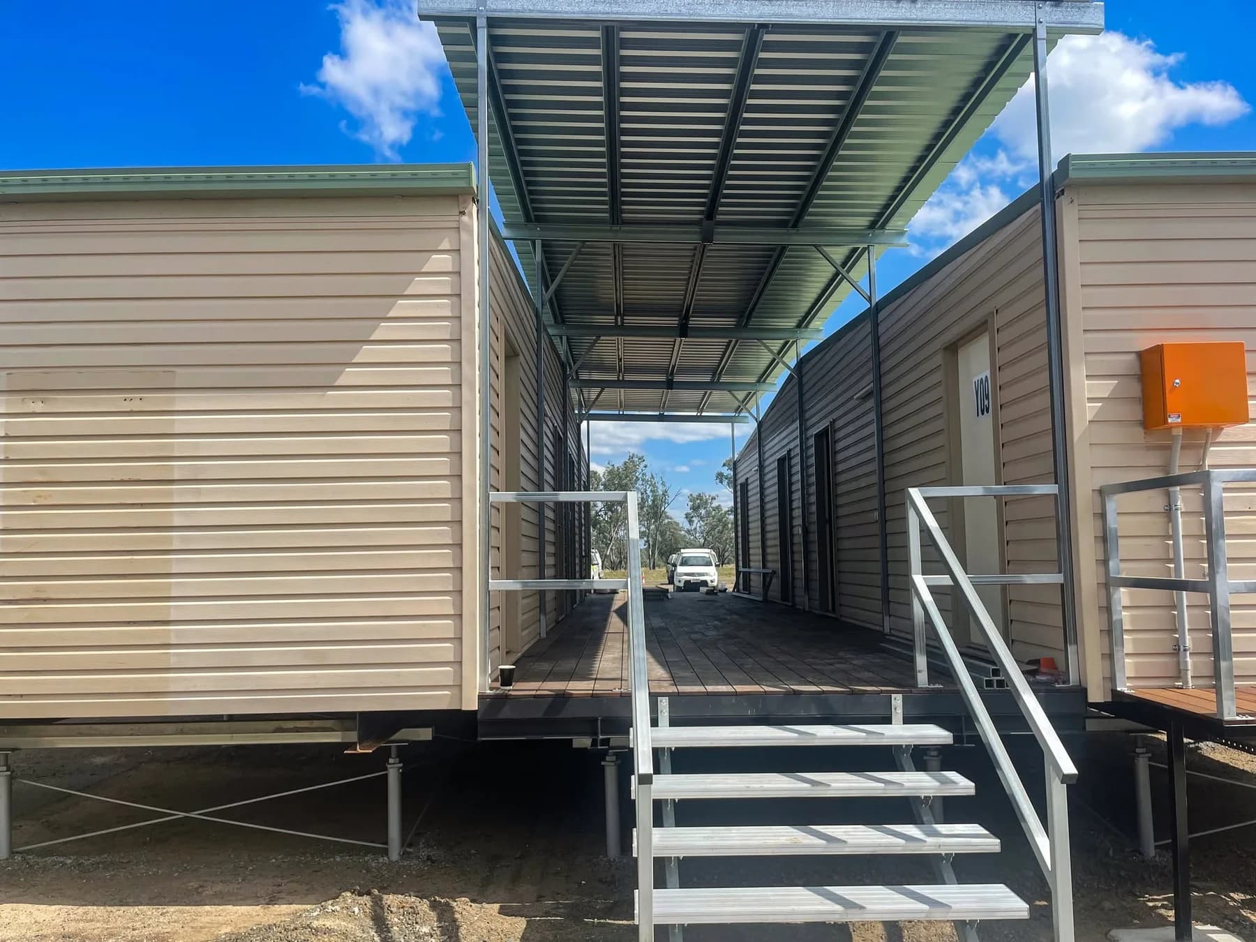 Metal stairs leading to a covered deck between two accommodation buildings