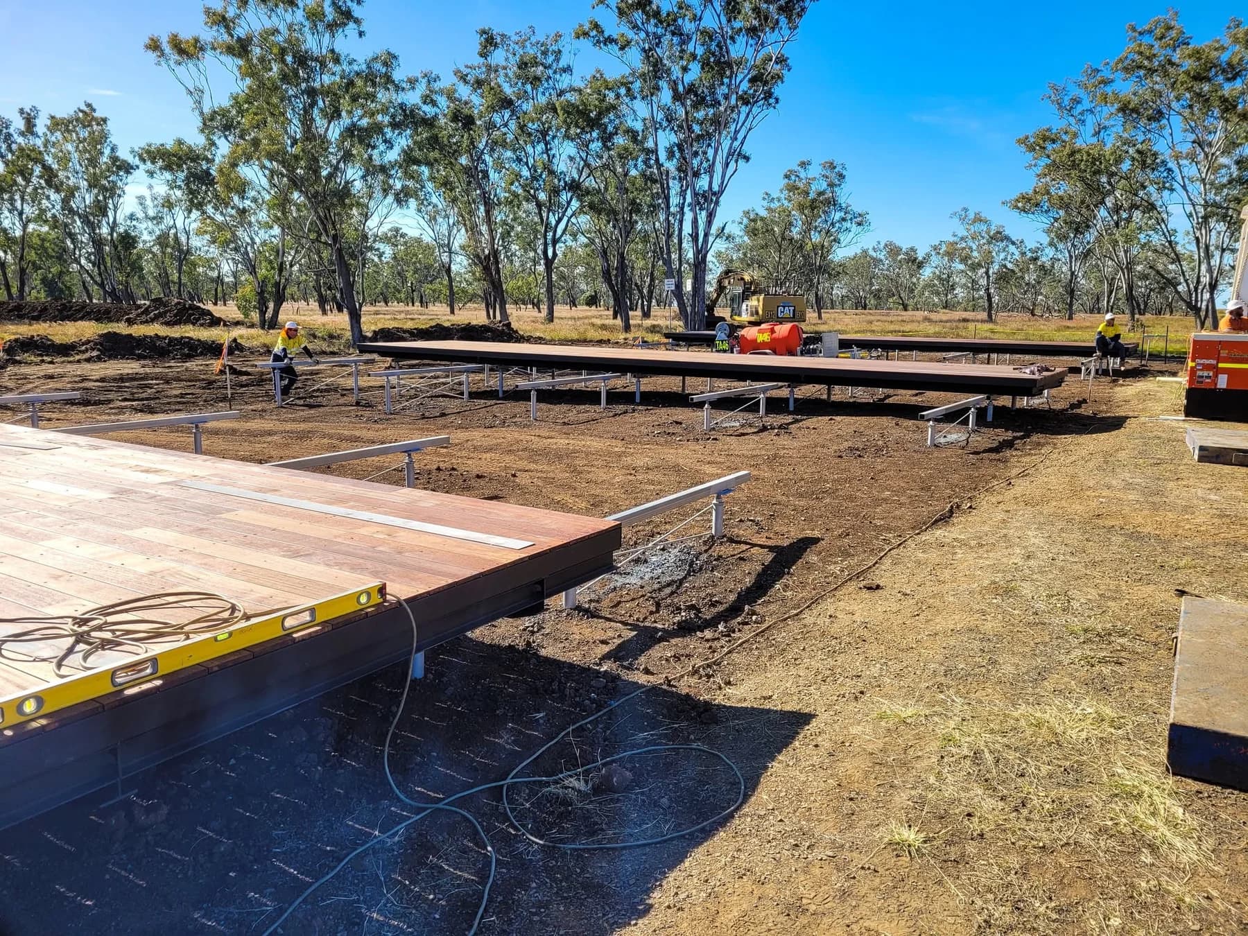 Workers positioning deck modules on steel supports before the surrounding buildings are installed