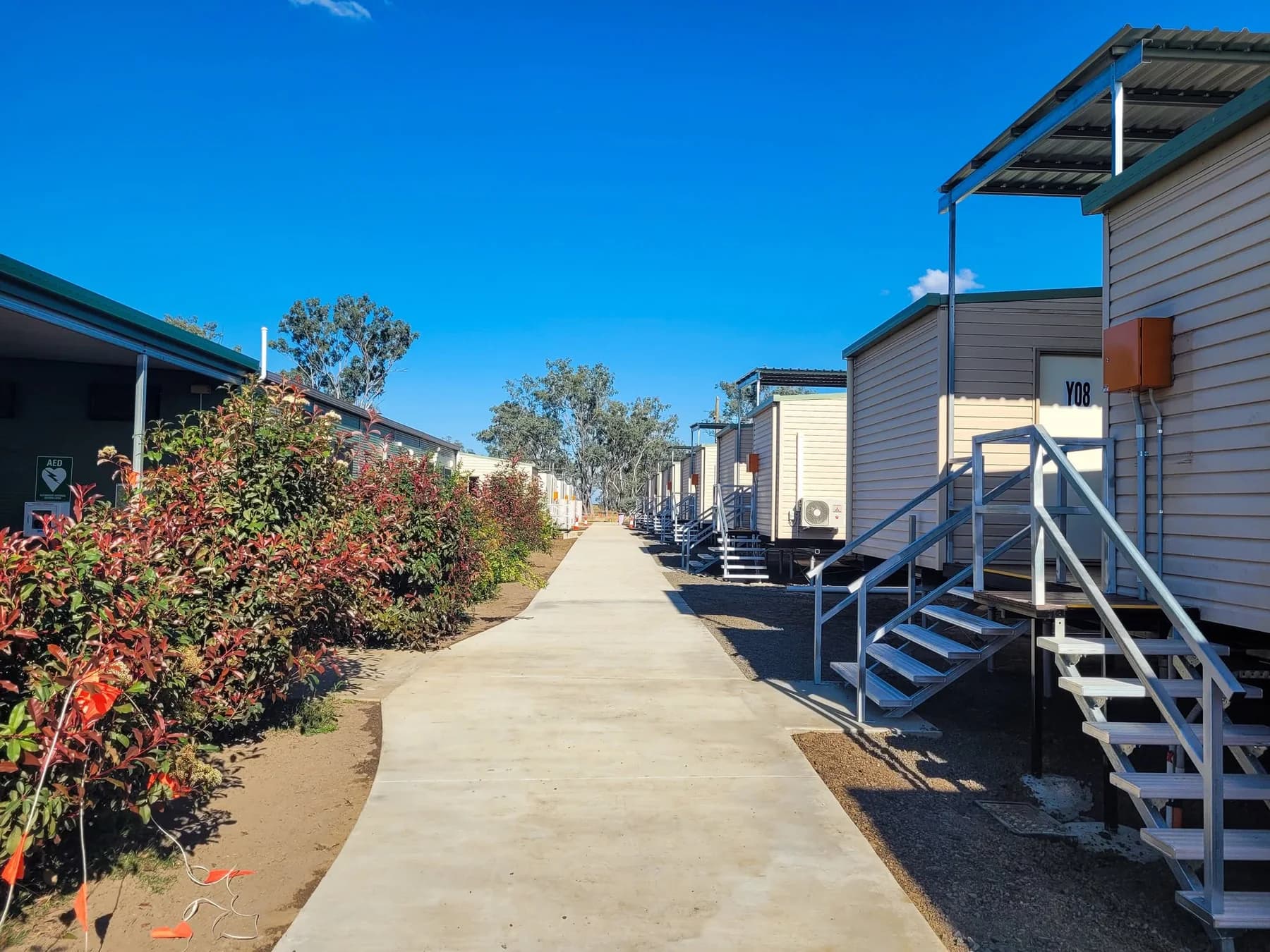 Concrete path beside a row of camp buildings with metal stairs and landings