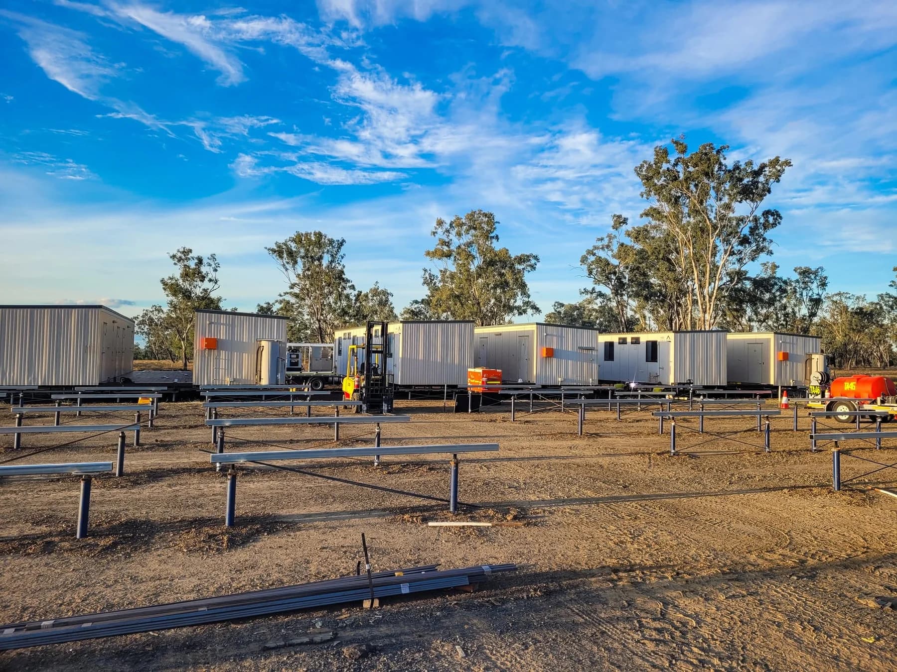 Steel beams and braced pile supports across a camp installation site