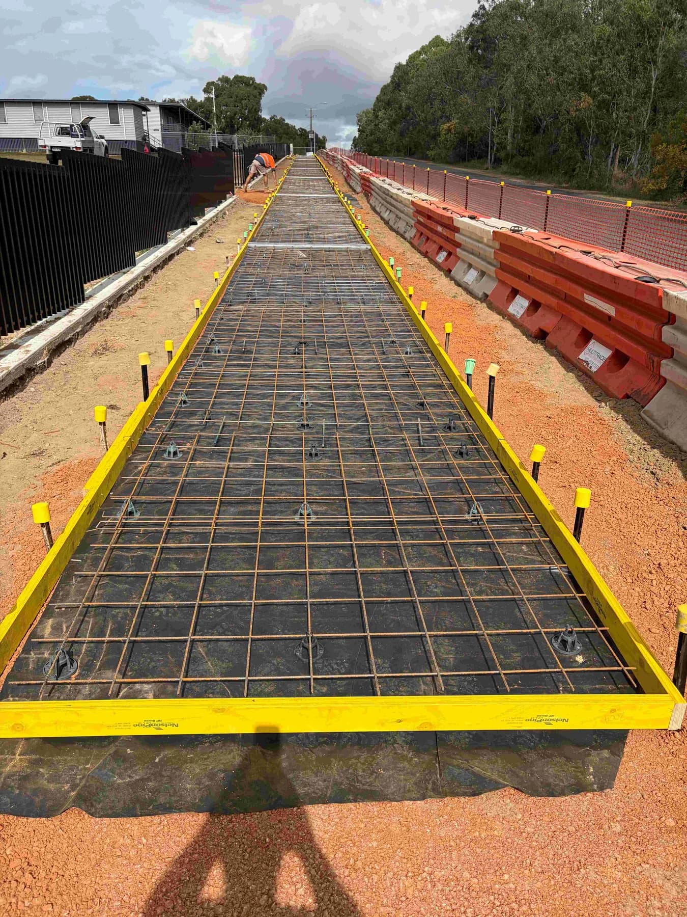 Reinforcing mesh and formwork set out along a building-side concrete path