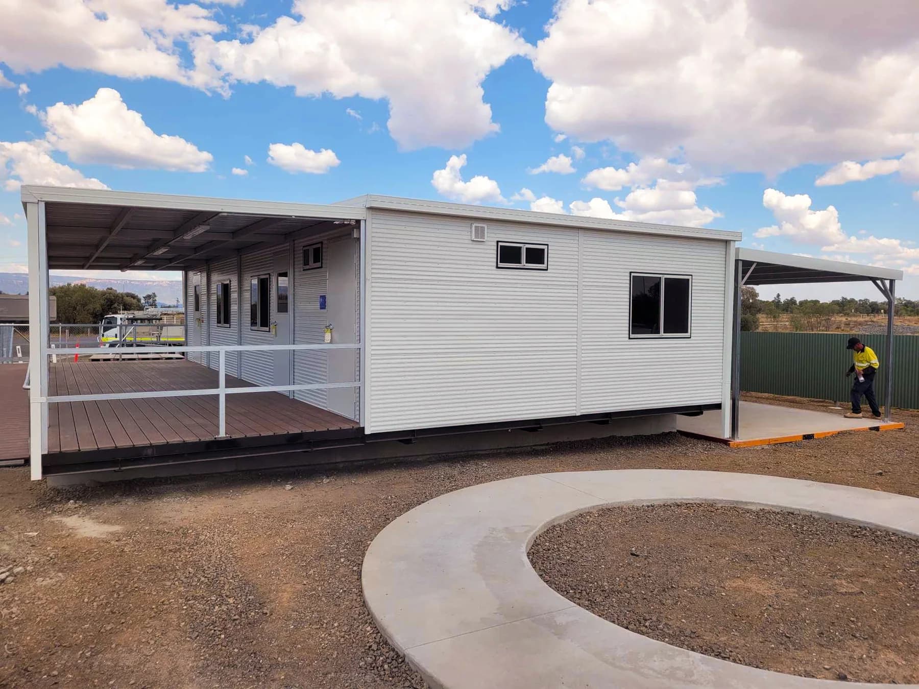 Portable building with a covered entry and a curved concrete approach
