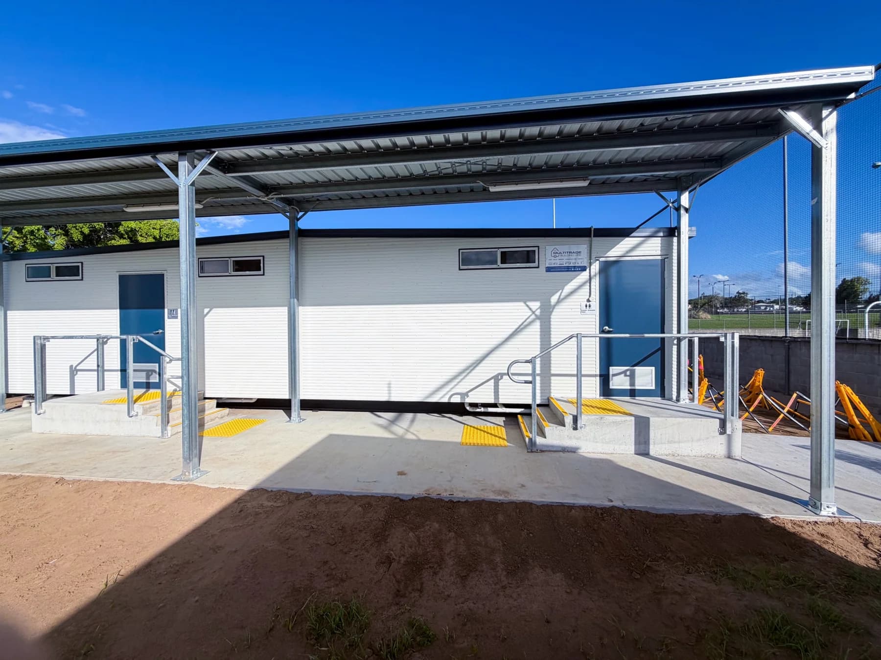 Amenities building with a steel canopy, concrete slab, entry landings and handrails