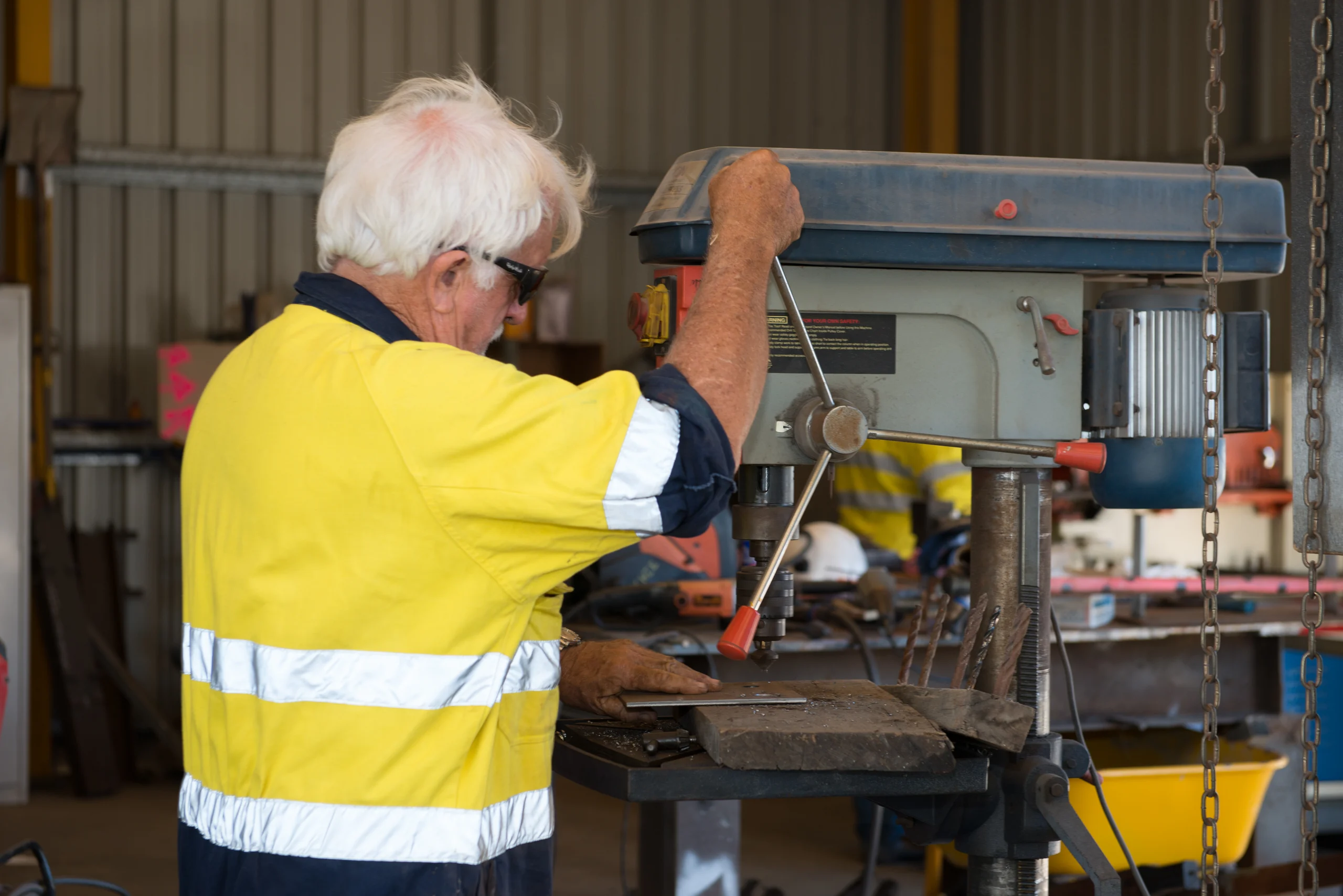 Fabrication work at a pedestal drill in the Multitrade workshop
