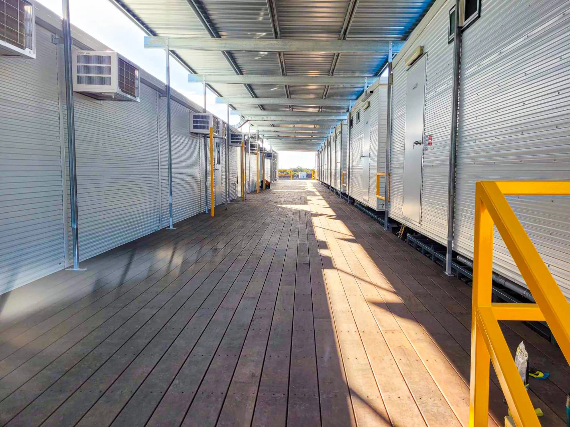 A roofed timber walkway connecting rows of portable buildings