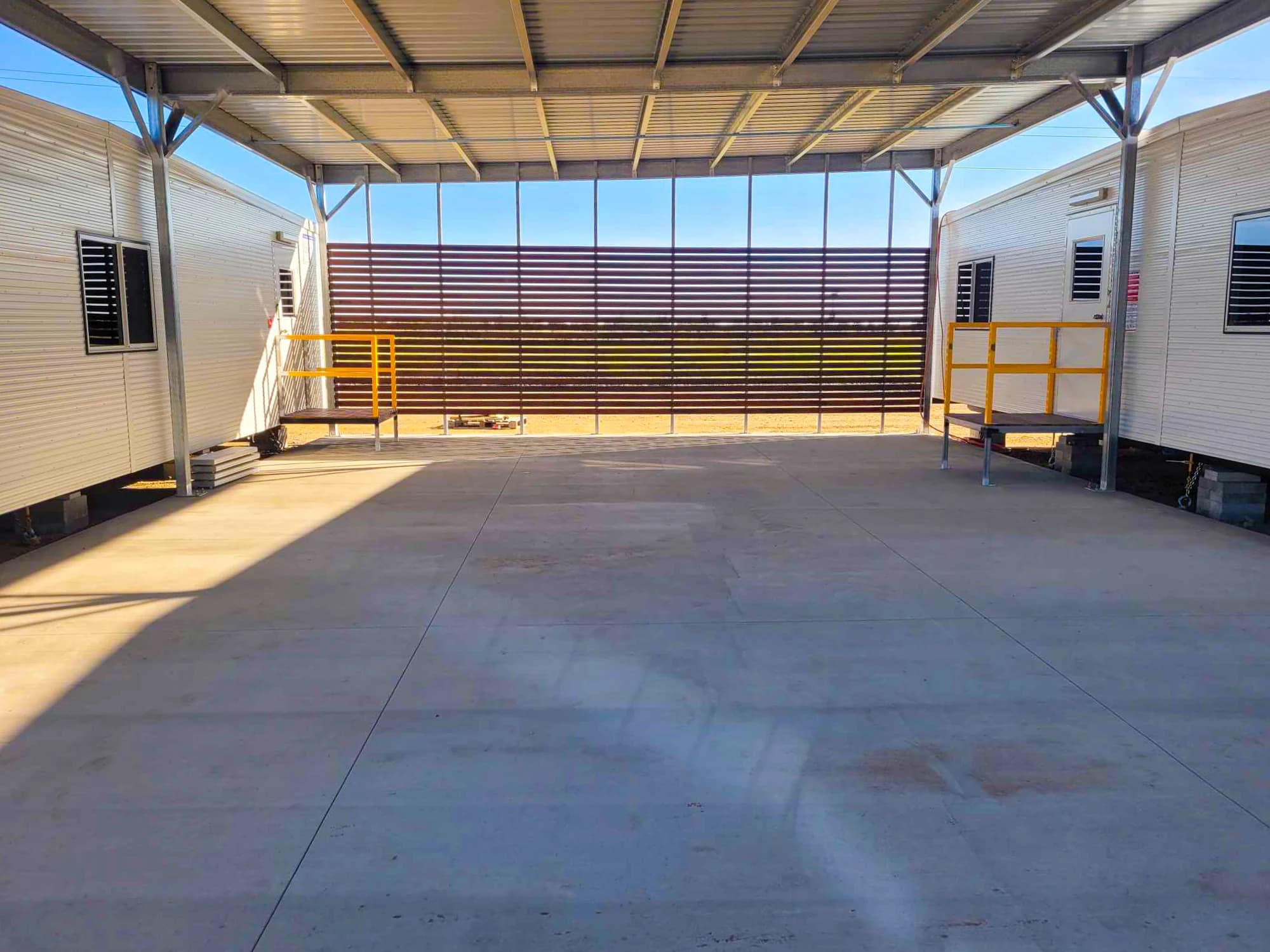 Roofed concrete area with screening between buildings at Peak Downs 3 North
