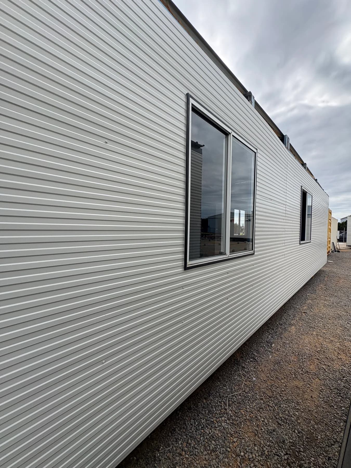 New cladding and window fitted along a portable building during renovation