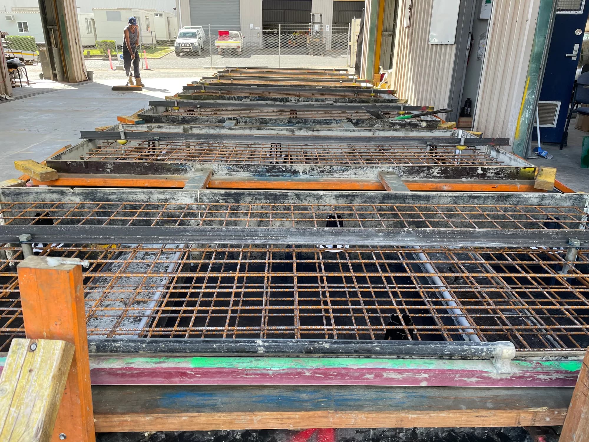 Reinforcement mesh within a row of custom footing forms before concrete is poured