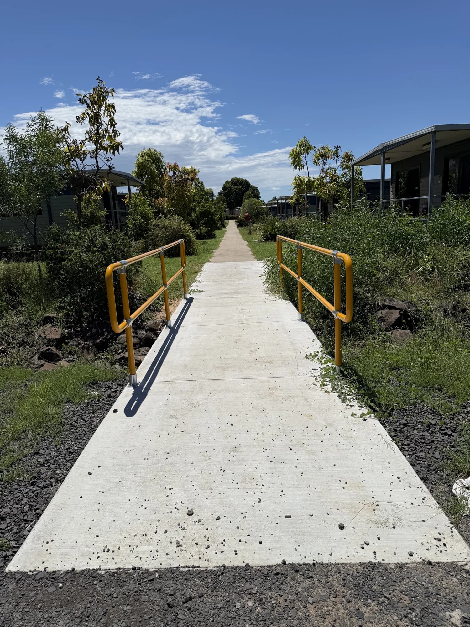 Concrete approach and yellow handrails leading between buildings