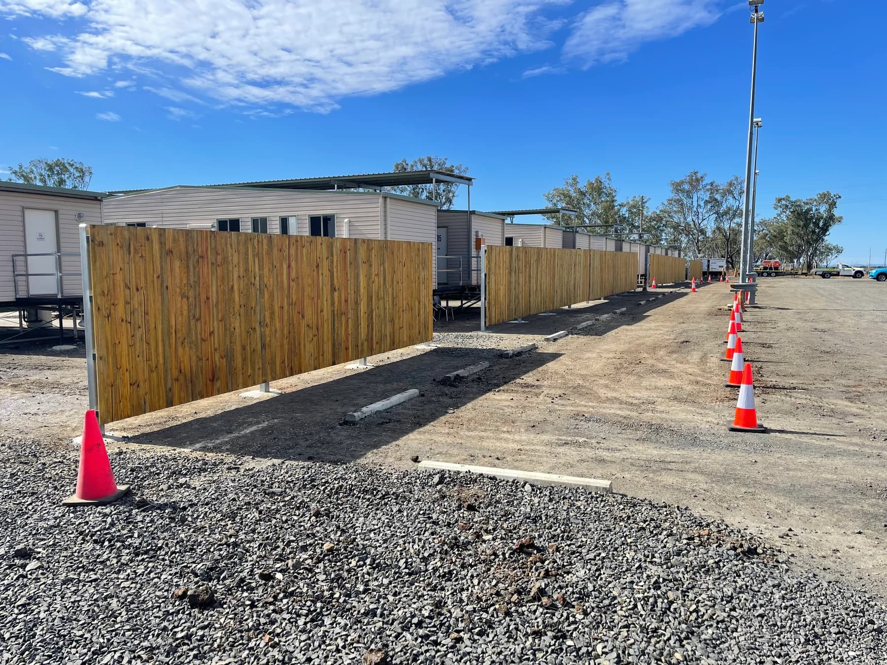 Timber paling fencing on steel posts beside portable site buildings